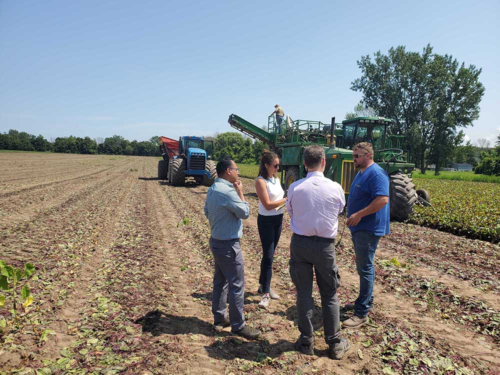 Cornell researchers and staff meet with farmer
