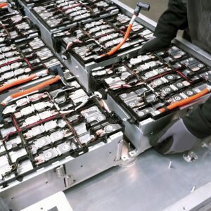 Worker moving EV batteries into place