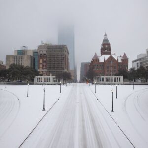 Pedestrians walk snowy streets in downtown streets during rush hour in downtown Dallas, during Winter Storm Uri in February 2021