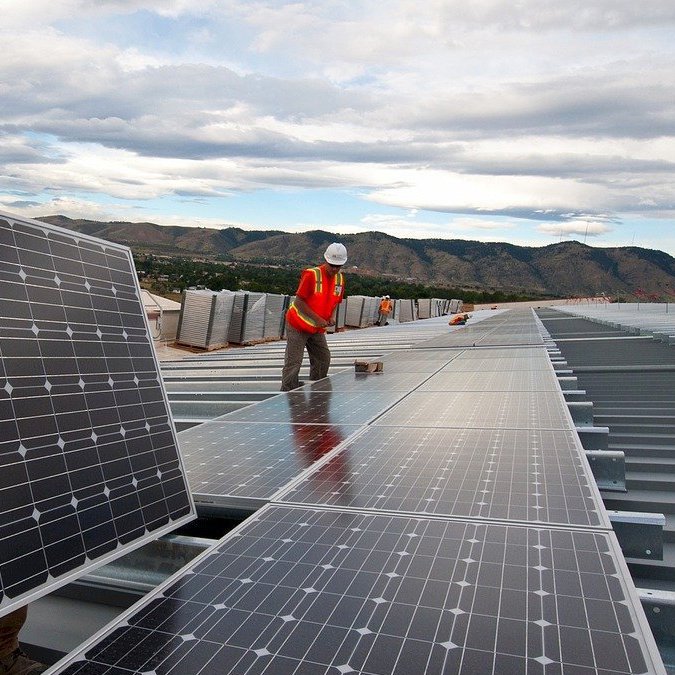 Workers installing solar panels in an array