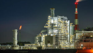 Factory in Europe emitting flame plumes from smokestacks