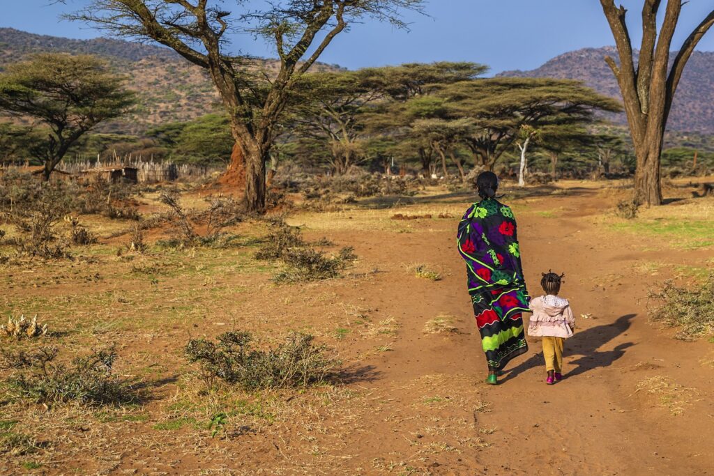 Woman from Borana tribe walking with her child in southern Ethiopia, Africa. The Borana Oromo are a pastoralist tribe living in southern Ethiopia and northern Kenya.