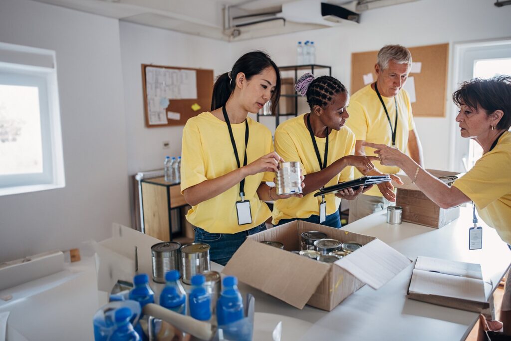 Relief workers sorting through canned food and water bottles into cardboard boxes (iStock)